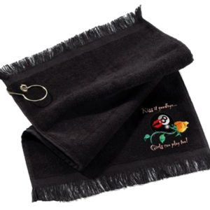 A black towel with a flower and key chain on it.